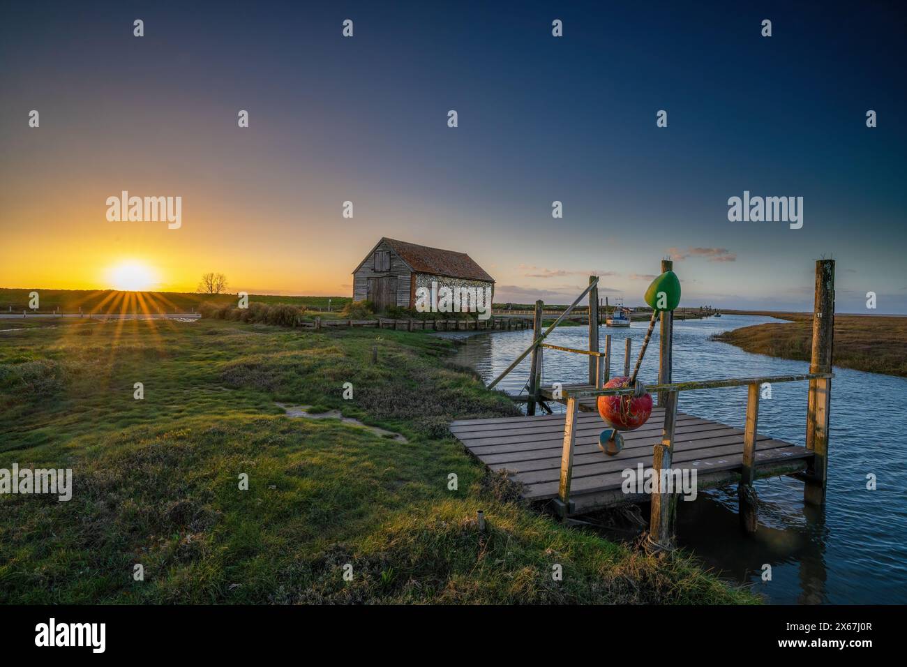 Il vecchio Coal Barn e Quay a Thornham Old Harbour, durante il tramonto. Thornham Norfolk, Inghilterra, Regno Unito Foto Stock