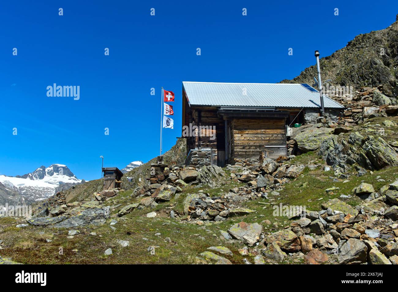 Bietschhornhütte, sul palo di bandiera le bandiere della Svizzera, del Canton Vallese e del Club Alpino accademico di Berna AACB, Lötschental, Vallese, Svizzera Foto Stock