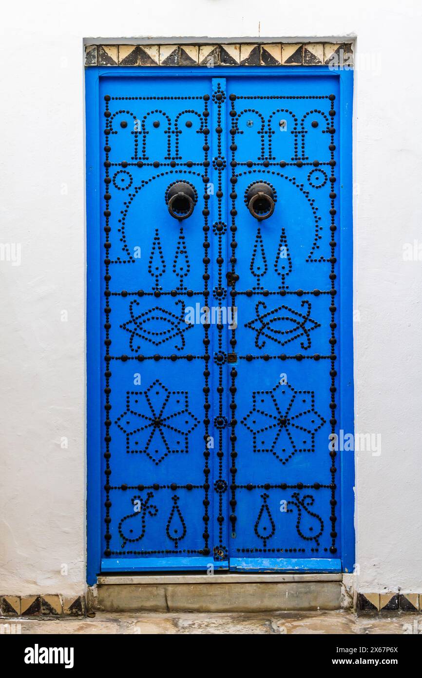 Porta blu decorativa. Tipica porta in legno borchiato blu o in ferro a Sidi Bou Said, Tunisia, Nord Africa Foto Stock