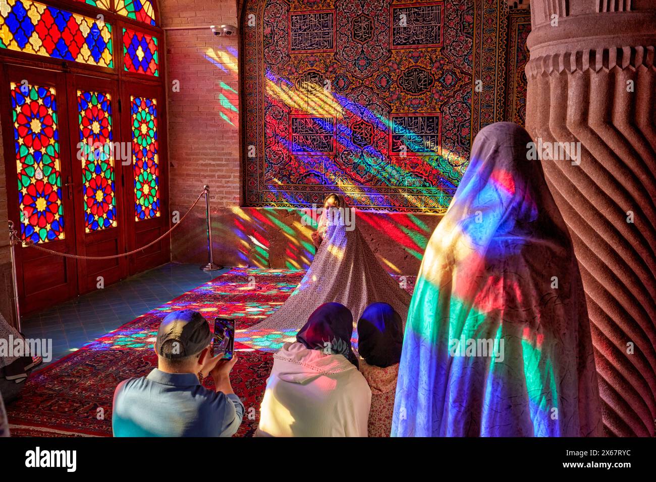 I turisti scattano foto all'interno della Moschea Nasir al-Mulk del XIX secolo, nota anche come Moschea Rosa, con le sue vetrate colorate. Shiraz, Iran. Foto Stock