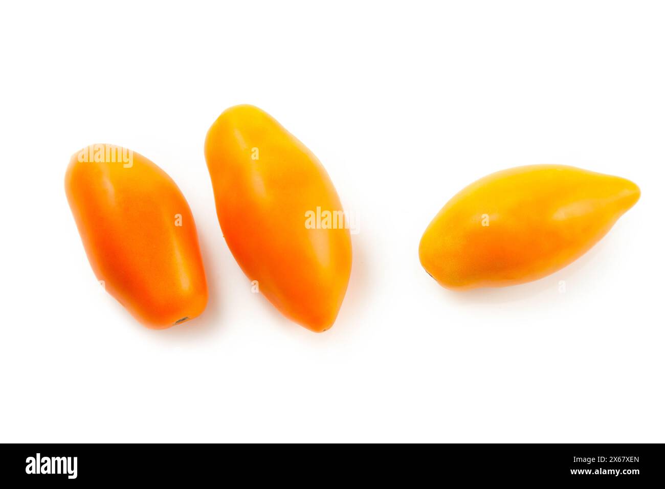 Tre pomodori gialli succosi interi con ombre morbide isolate su sfondo bianco con percorso di ritaglio. Raccolta di verdure su bianco. Foto Stock