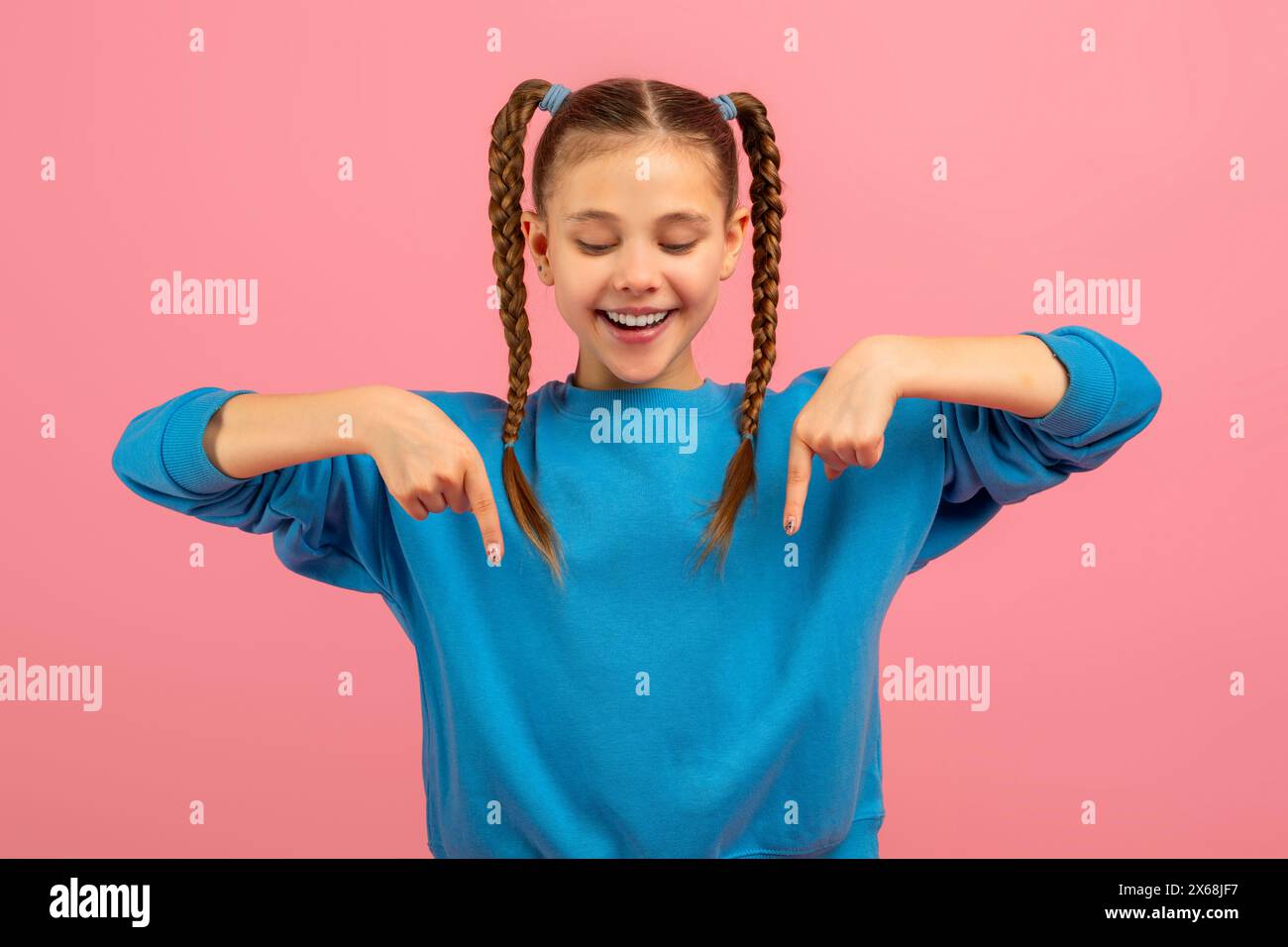 Sorridente ragazza con trecce intrecciate rivolte verso il basso Foto Stock