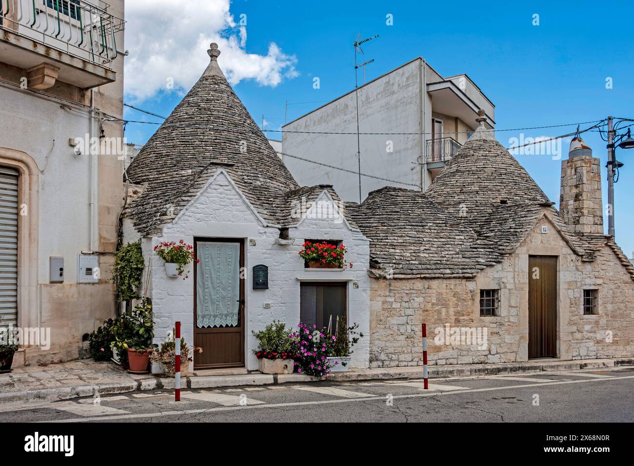 Case Trulli tradizionali sotto un cielo azzurro a Alberobello, Italia Foto Stock