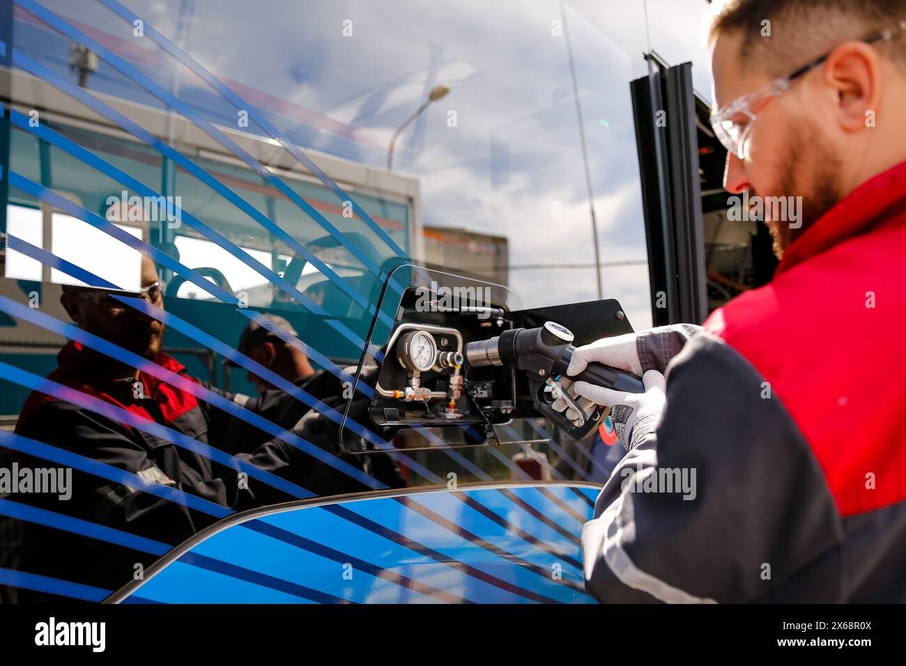 Cracovia, Polonia. 13 maggio 2024. Un engeneers alimenta un autobus a idrogeno durante una conferenza stampa mentre Cracovia introduce un nuovo autobus a idrogeno Mercedes-Benz eCitaro Fuel Cell nel suo trasporto pubblico a Cracovia, in Polonia, il 13 maggio 2024. Il nuovo autobus alimentato a idrogeno si unirà alla flotta di Cracovia su una linea di autobus regolare. L'autobus viene trasportato da una stazione mobile. Cracovia prevede di far crescere la flotta di idrogeno. Crediti: Dominika Zarzycka/Alamy Live News crediti: Dominika Zarzycka/Alamy Live News Foto Stock