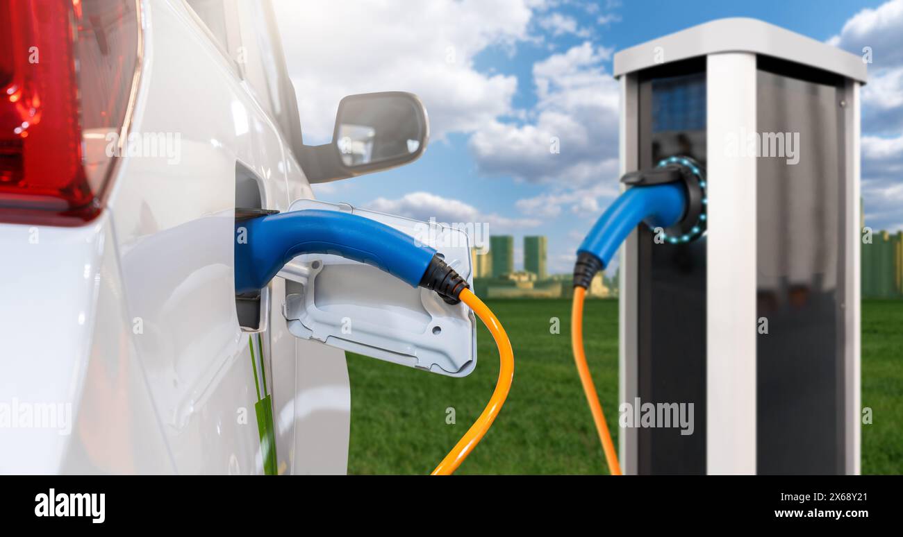 Primo piano di un'auto elettrica con un cavo di ricarica collegato sullo sfondo di una città ecologica verde. Foto Stock