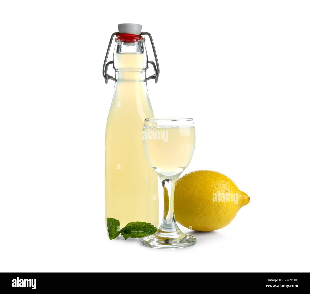 Bicchiere e bottiglia di saporito limoncello su sfondo bianco Foto Stock