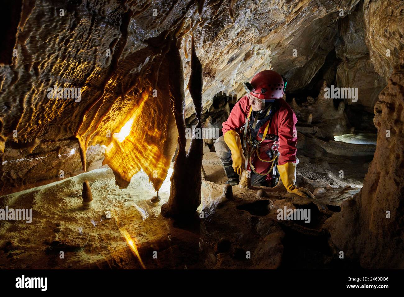 esploratore della grotta in una grotta osserva una meraviglia naturale Foto Stock