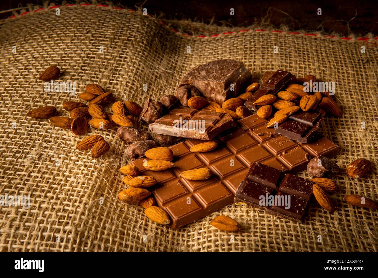Fotografia orizzontale di una varietà di cioccolatini con mandorle su un sacchetto di iuta Foto Stock