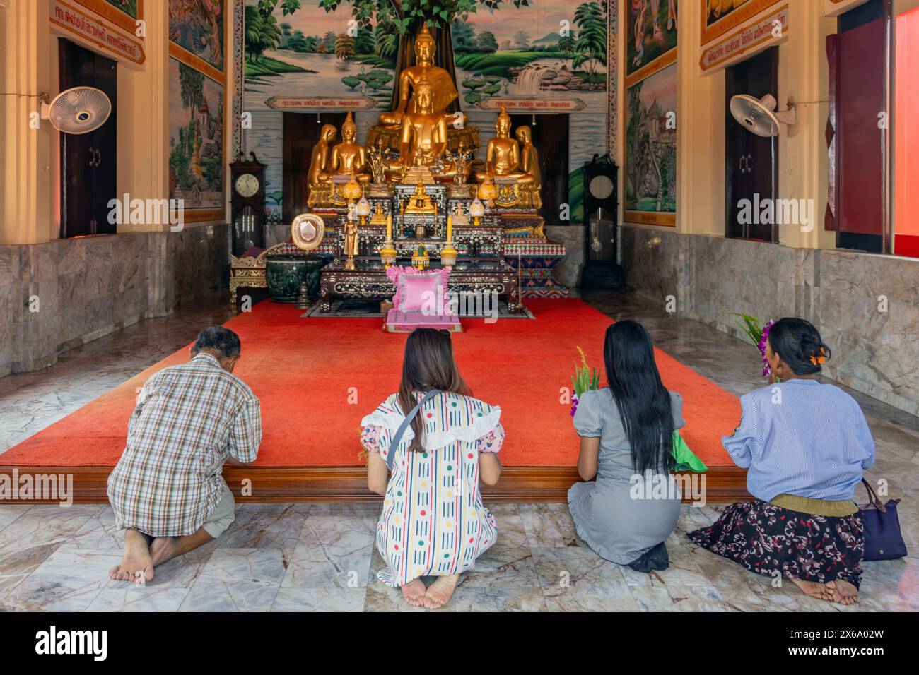 RATCHABURI, THAILANDIA, 24 marzo 2024, Una famiglia prega insieme in un tempio buddista Wat Khao noi Tian Sawan Foto Stock