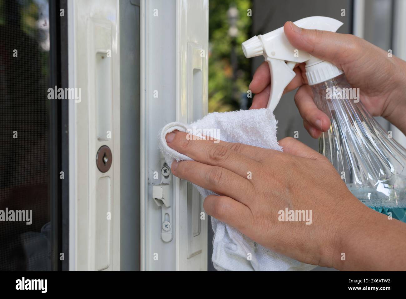 L'operatore utilizza un panno morbido per pulire i telai delle porte in alluminio uPVC e rimuove un po' di sporco dopo l'installazione. Foto Stock