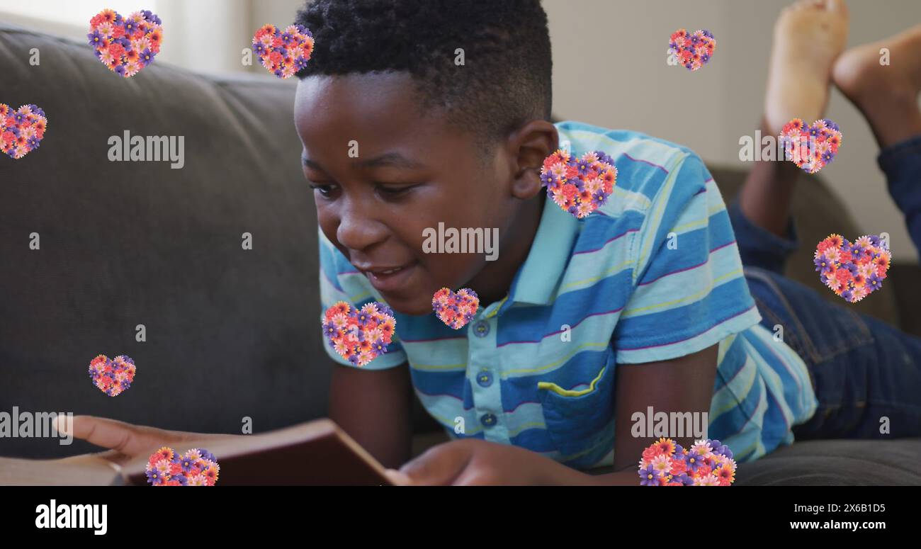 Immagine di icone del cuore con fiori su un libro di lettura afroamericano Foto Stock