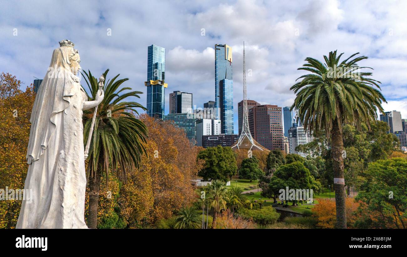 Melbourne, Australia. Statua della Regina Vittoria in piedi nei Queen Victoria Gardens con lo skyline di Melbourne sullo sfondo. Foto Stock