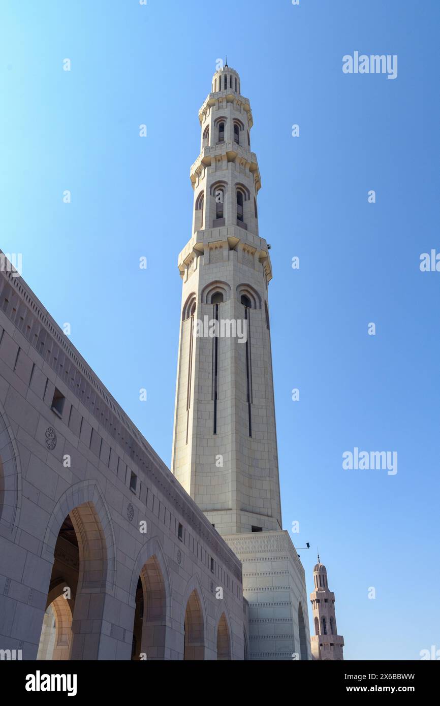 Un minareto torreggiante sorge in un'elegante grandiosità contro il cielo azzurro, mostrando intricati dettagli architettonici. Foto Stock