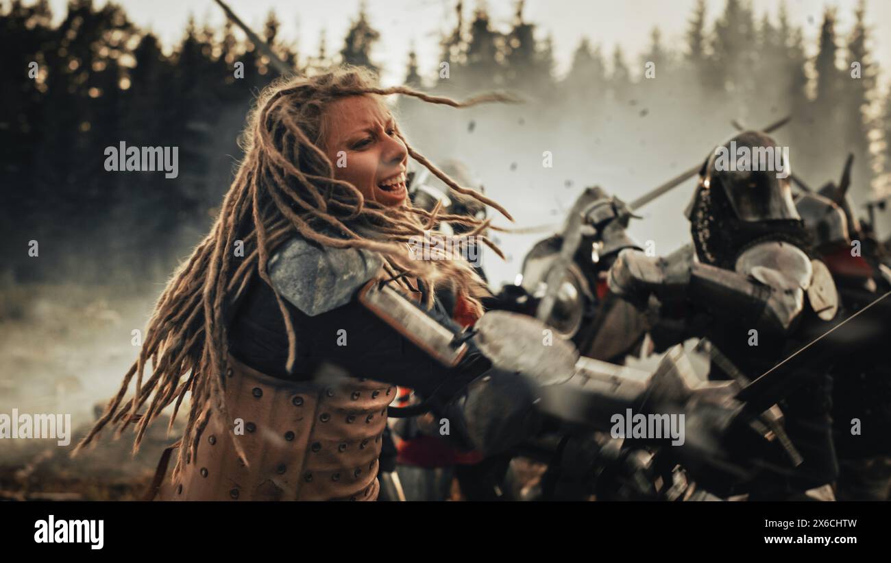 Epico campo di battaglia: Potente guerriero femminile che attacca, combatte con la spada e colpisce il nemico con colpi mortali. Dark Age Medieval Battle of Knight Soldiers. Rievocazione storica cinematografica. Foto Stock
