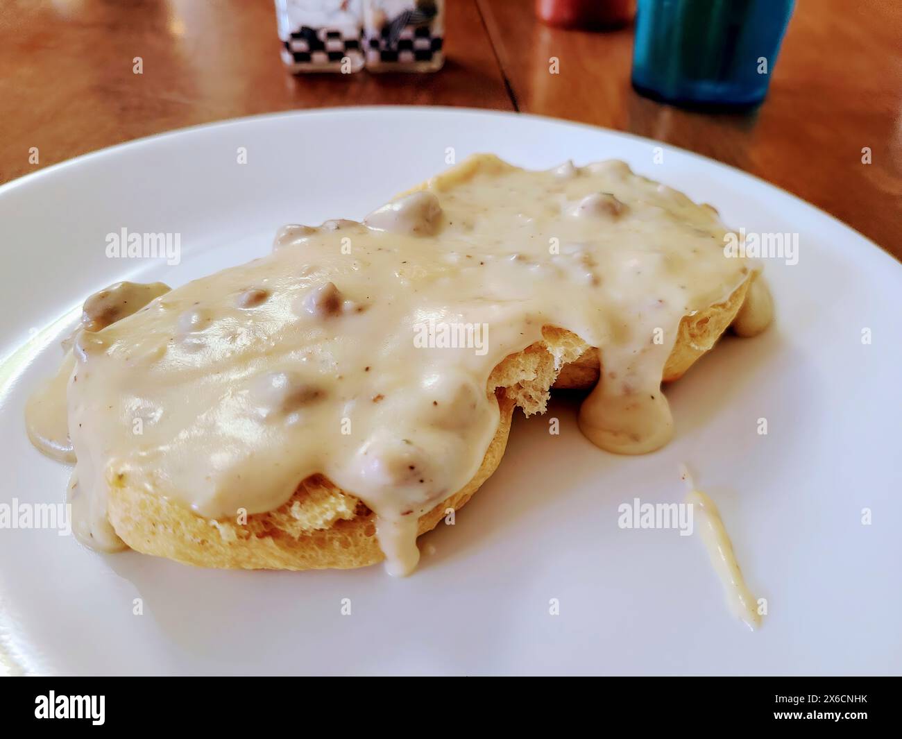 Sostanziosi biscotti del sud con sugo di carne su piatto bianco, vista a livello dell'occhio Foto Stock