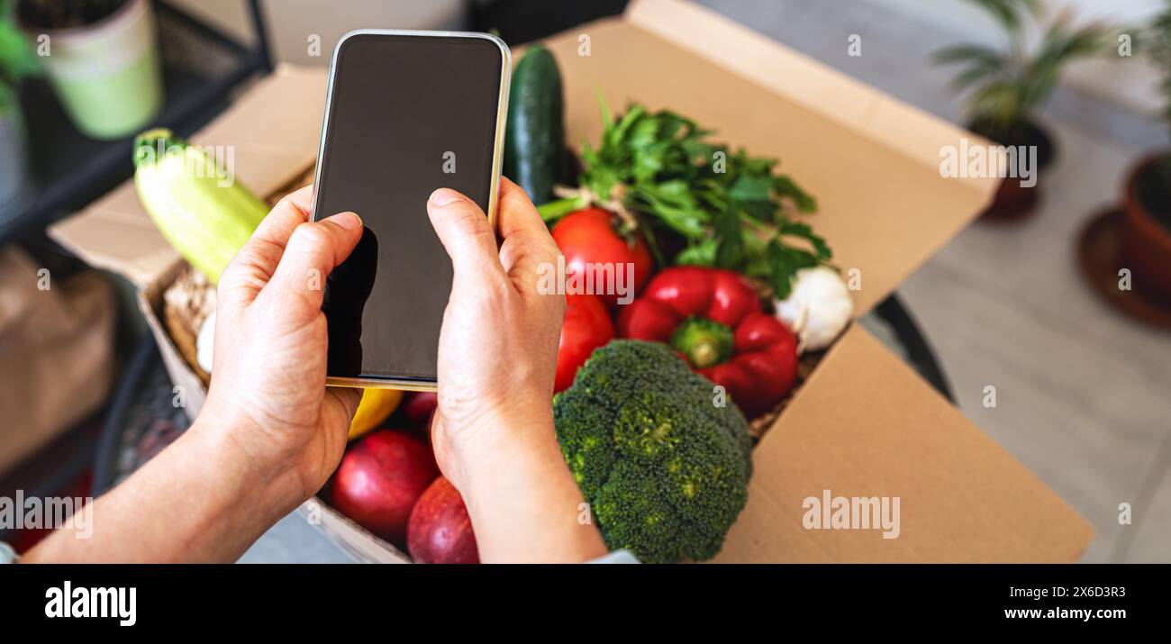 Ordinazione e consegna online di prodotti alimentari. consegna di cibo sano e vegetariano. Foto Stock