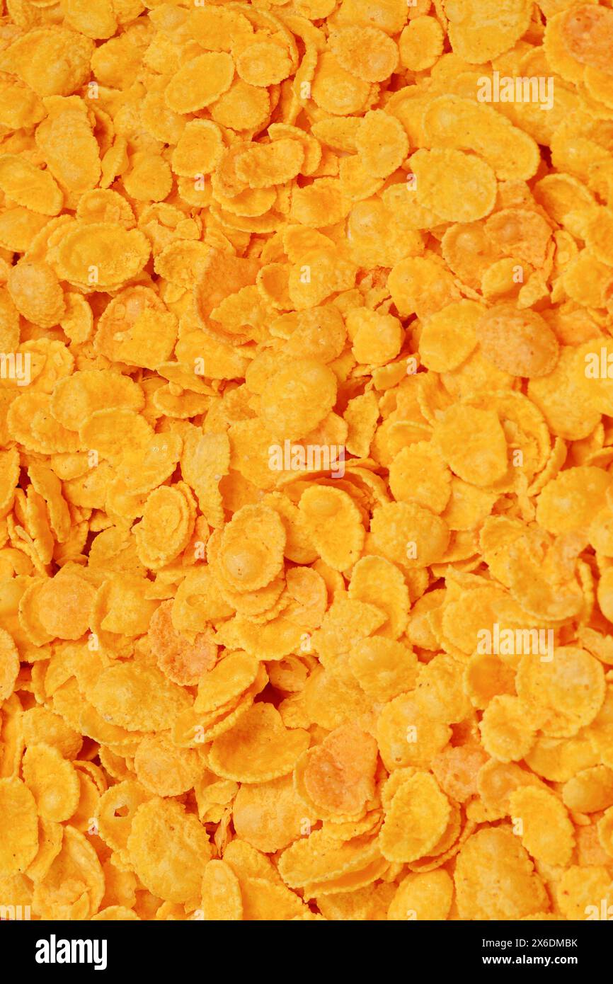 Sfondo e consistenza di corn-flakes. Vista dall'alto. scatola di cereali con fiocchi di mais per colazione. Foto Stock