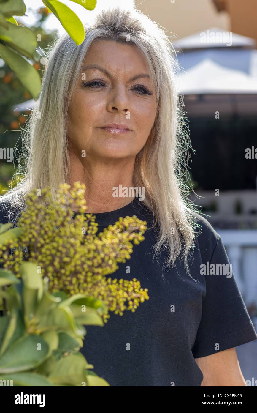 Questo ritratto mostra la bellezza senza tempo di una donna di 50 anni con capelli biondi radiosi. Foto Stock