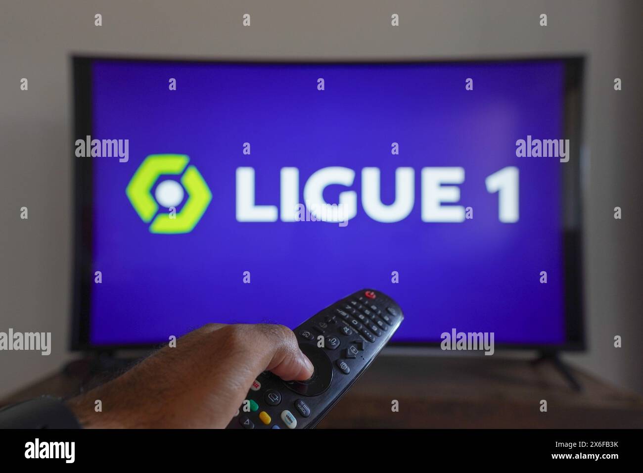 Brasile. 13 maggio 2024. In questa immagine, una mano che tiene premuto il telecomando del televisore davanti al logo Ligue 1 sullo schermo del televisore. Credito: SOPA Images Limited/Alamy Live News Foto Stock