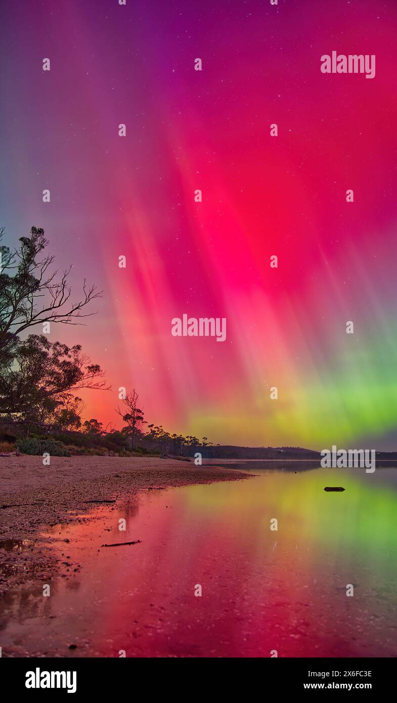 Aurora Australis luci meridionali tempesta solare cielo arcobaleni con riflessi, catturati da Gorringes Bach vicino a Hobart, Tasmania, Australia Foto Stock