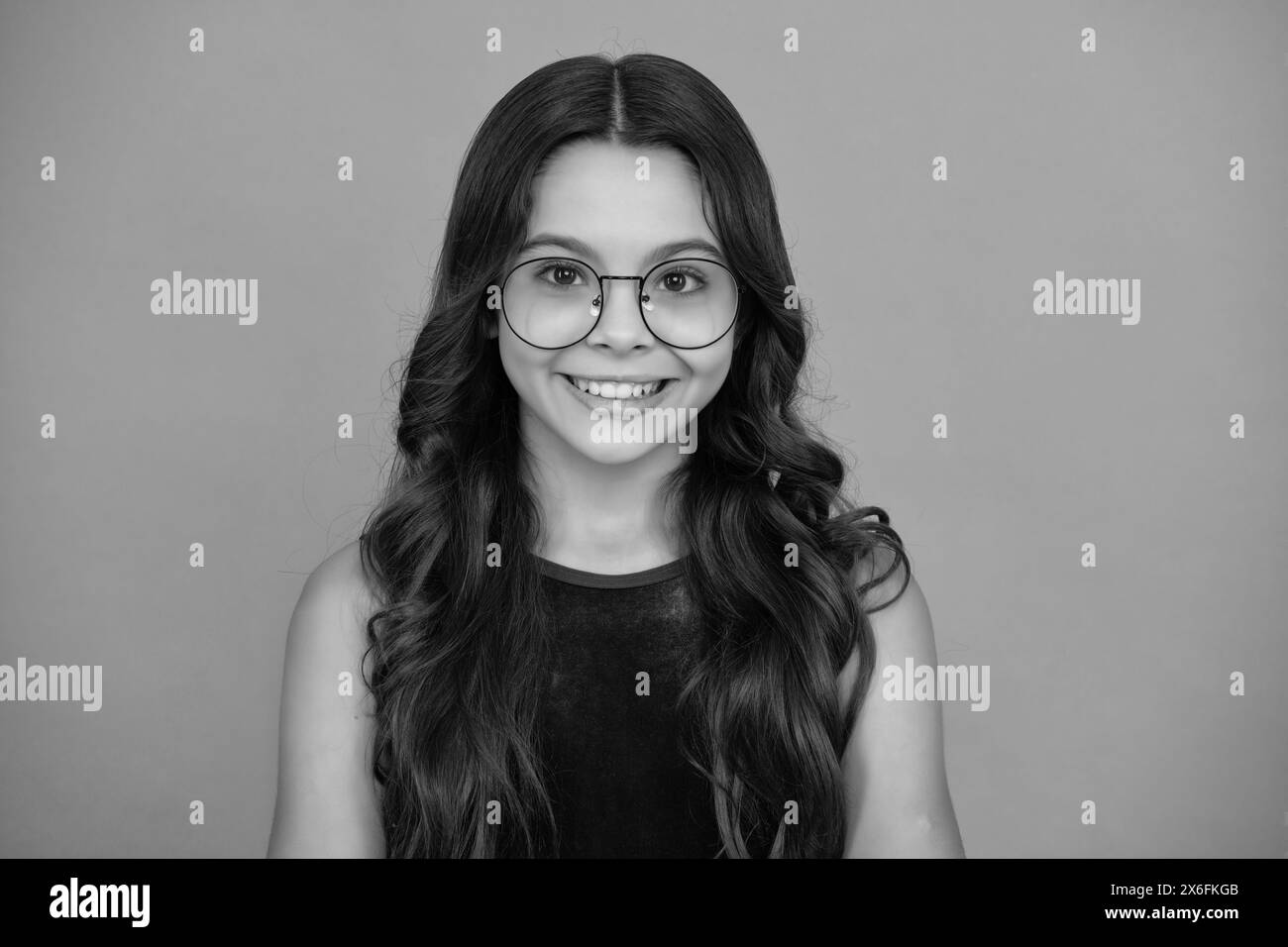 Faccia della ragazza felice, emozioni positive e sorridenti. Adorabile bambino sorridente isolato su sfondo bianco. Foto Stock