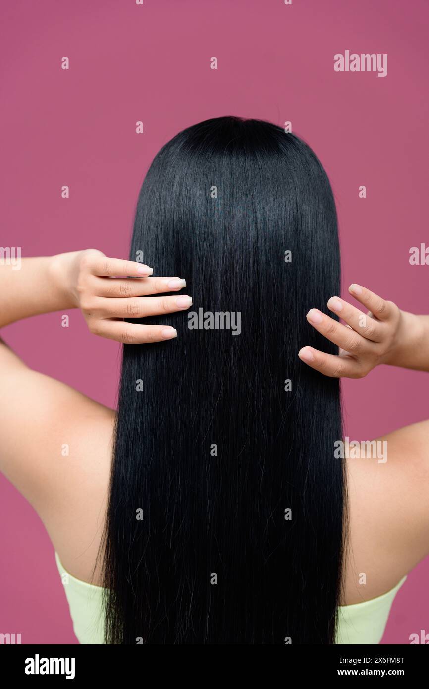 bellissimi capelli lisci isolati su sfondo rosa Foto Stock