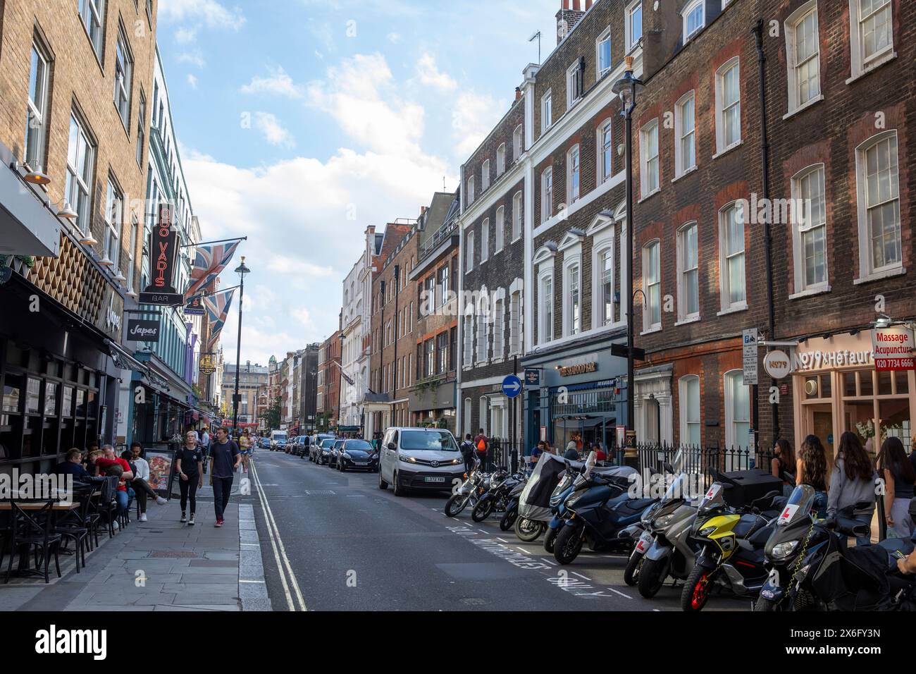 Dean Street nel centro di Londra Soho, architettura londinese Quo Vadis club privato e motociclette e scooter parcheggiati, Inghilterra, Regno Unito Foto Stock