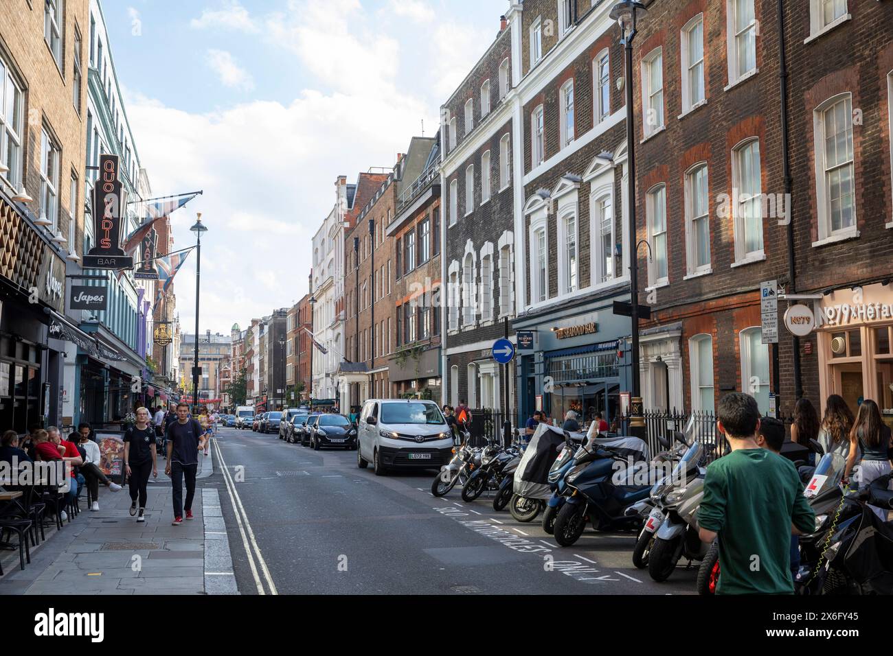 Dean Street nel centro di Londra Soho, architettura londinese Quo Vadis club privato e motociclette e scooter parcheggiati, Inghilterra, Regno Unito Foto Stock