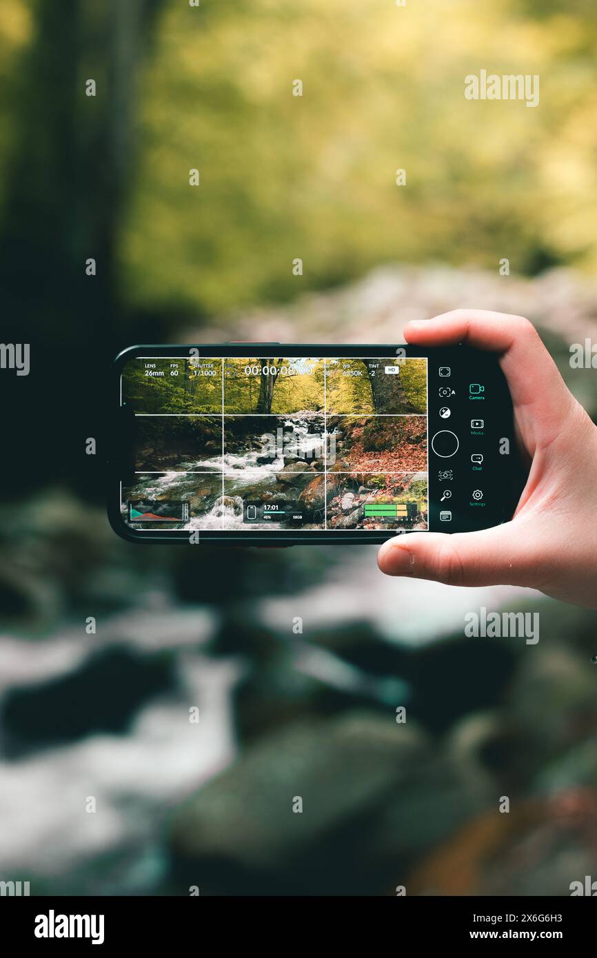 Riprese video paesaggistici della natura con gli splendidi alberi e il fiume in primavera. Usare una mano per tenere un telefono. Foto Stock