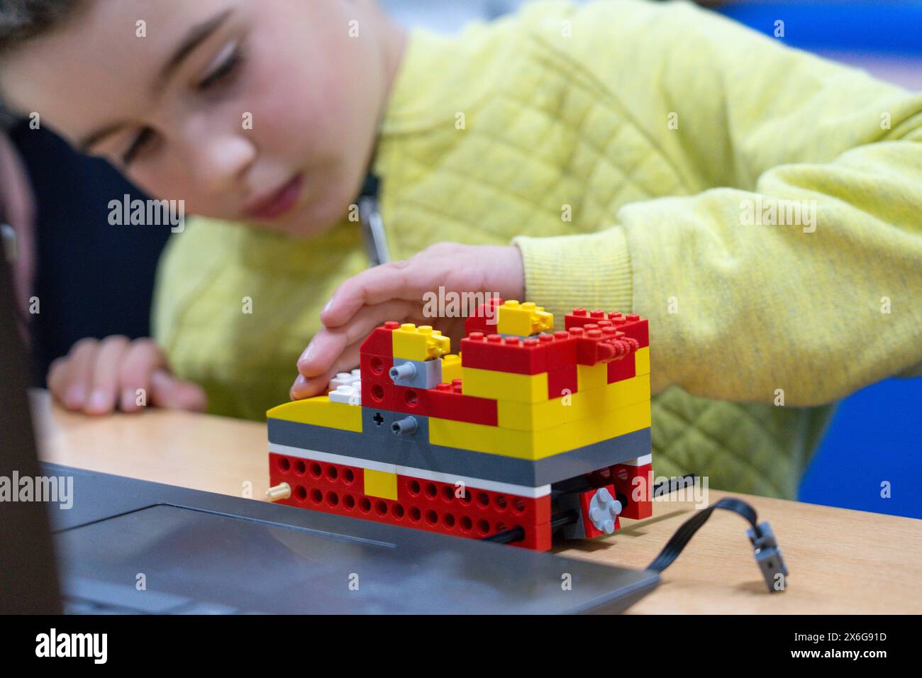 Ragazzo che costruisce un robot in una classe di robotica per bambini Foto Stock