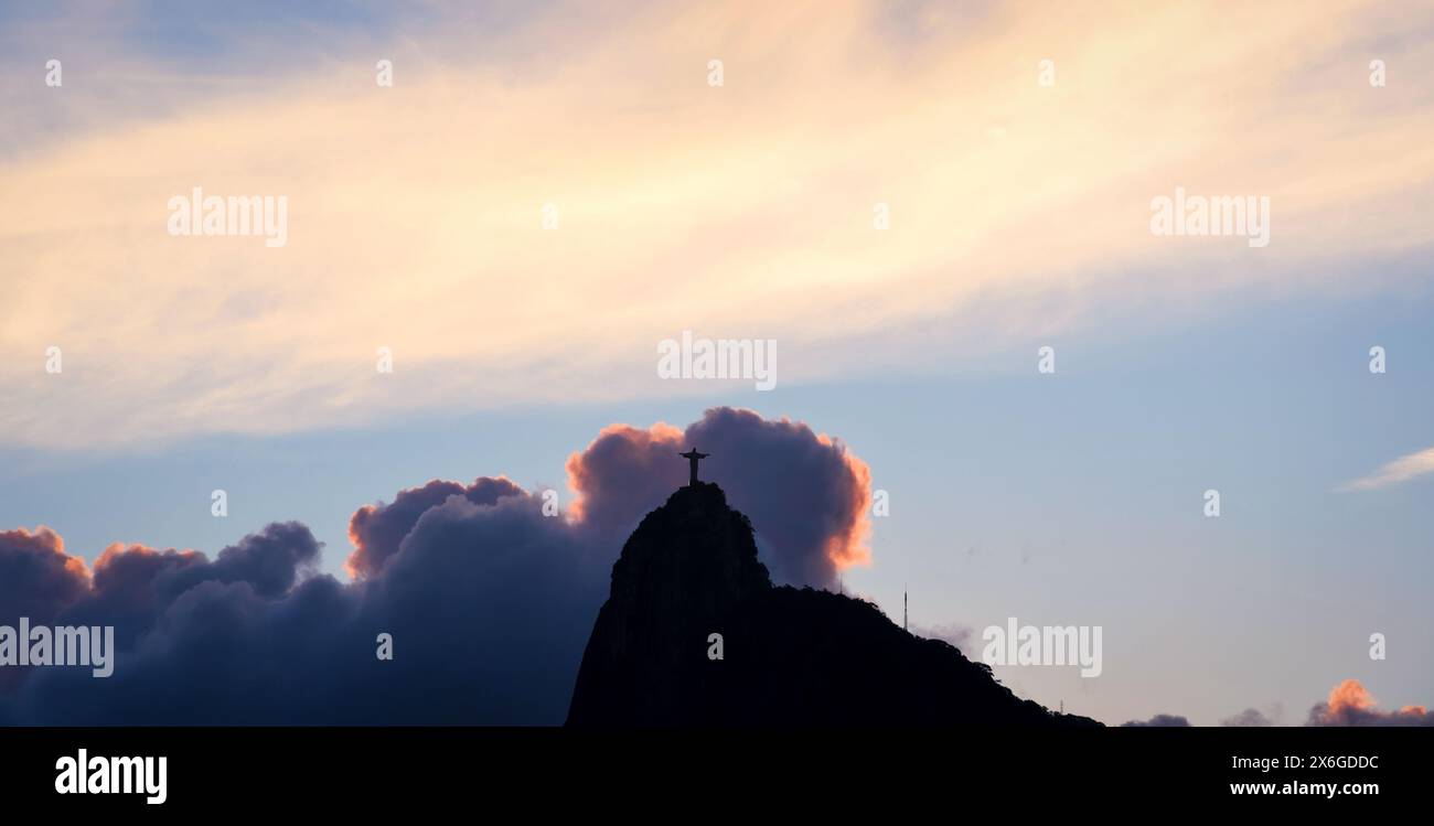 La statua del Cristo in cima al monte Corcovado, con splendidi cieli al tramonto - Rio de Janeiro, Brasile Foto Stock