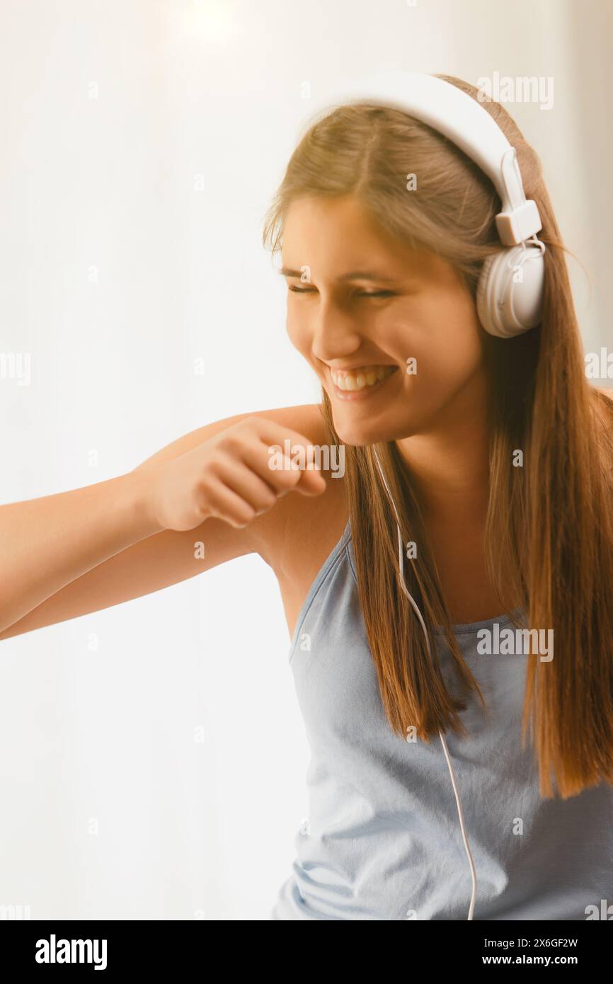 La giovane ballerina, irradia felicità, si muove al ritmo del ritmo, con le sue cuffie che la collegano a un mondo di suoni Foto Stock