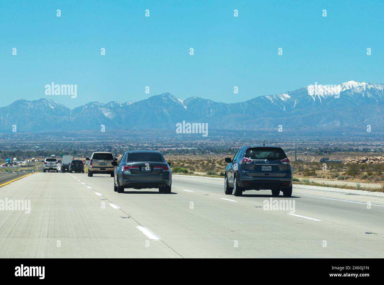 Traffico autostradale. Un grande flusso di auto si muove lungo l'autostrada in America, vista posteriore. Interstate Road in America, clima caldo, sole rovente. Americano Foto Stock