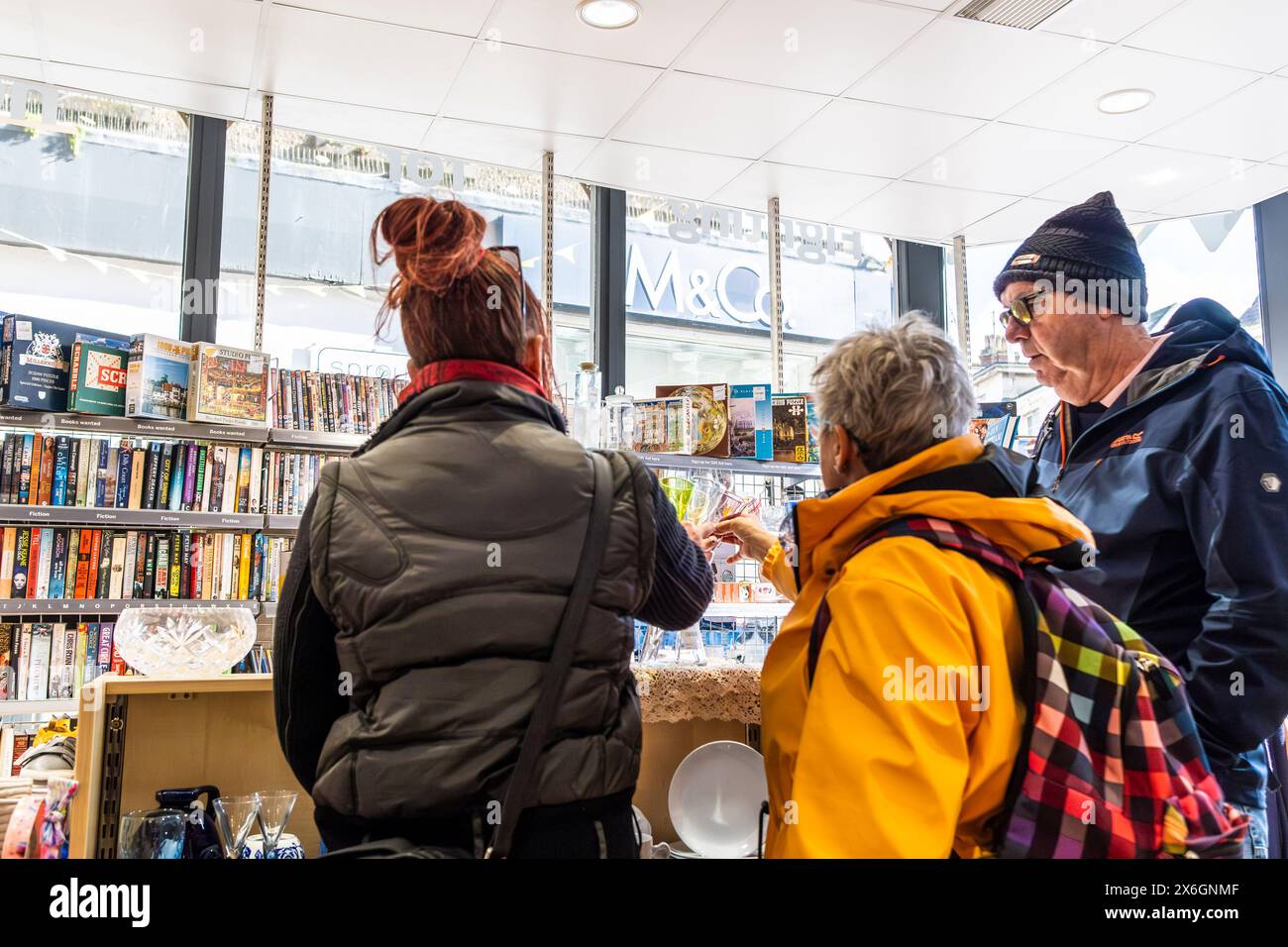 Gli acquirenti che navigano in un negozio di beneficenza a Newquay, in Cornovaglia, nel Regno Unito. Foto Stock