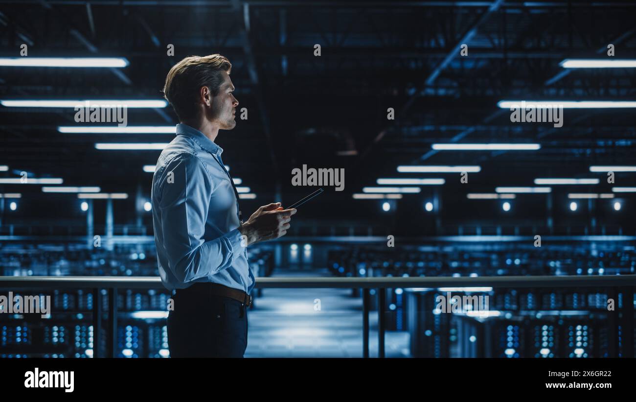 Bellissimo specialista IT sorridente che utilizza tablet computer nei data center. Imprenditore di successo e imprenditore di e-Business che lavora nella struttura di cloud computing di Big Server Farm. Foto Stock