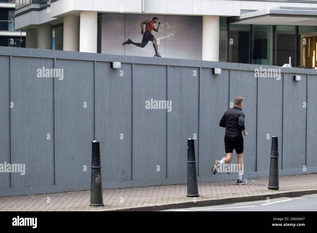 Runner interagisce con una figura stampata in un edificio vicino il 7 maggio 2024 a Londra, Regno Unito. Foto Stock