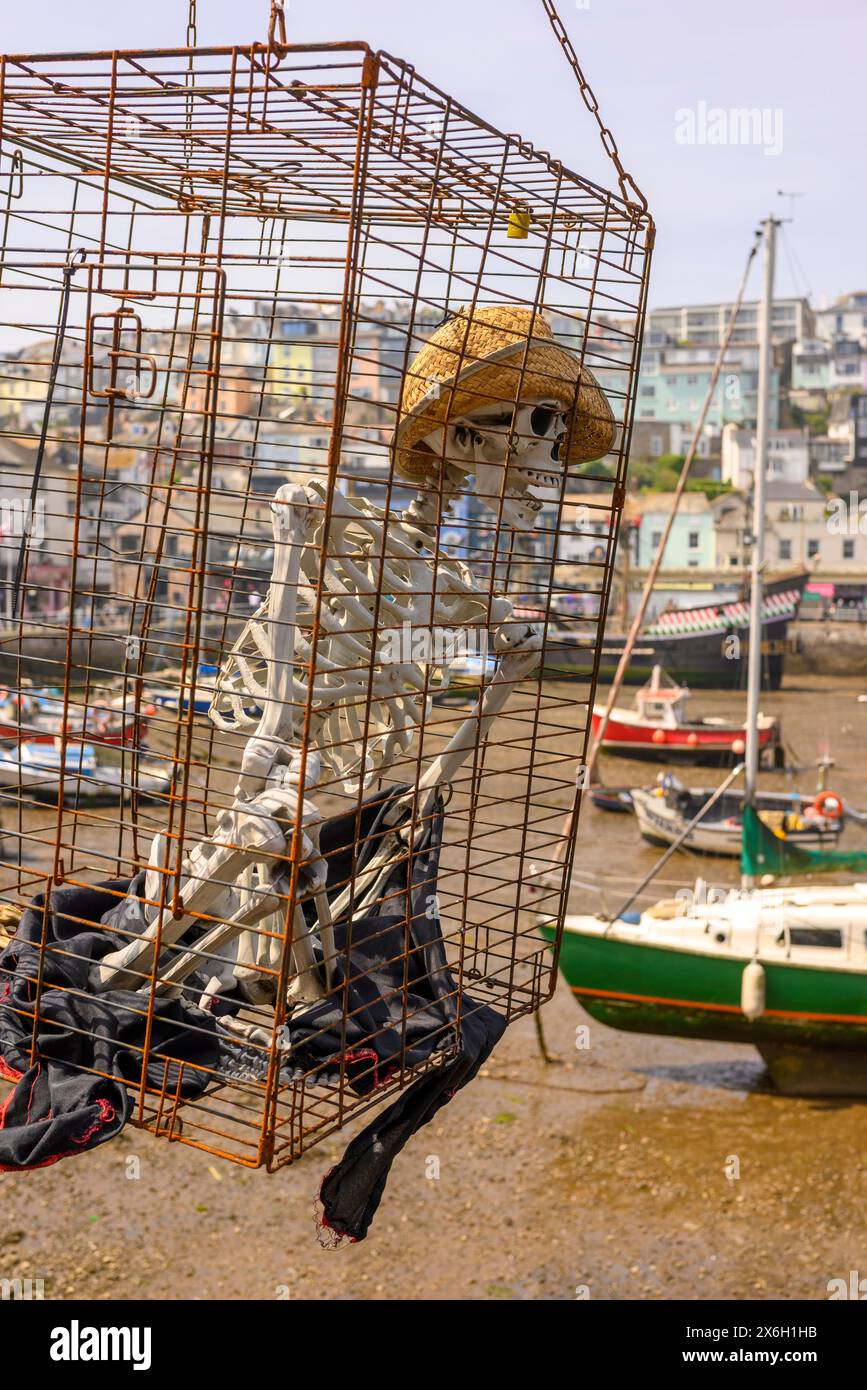 Scheletro in una gabbia appesa al porto, Brixham, Devon, Inghilterra, Regno Unito Foto Stock