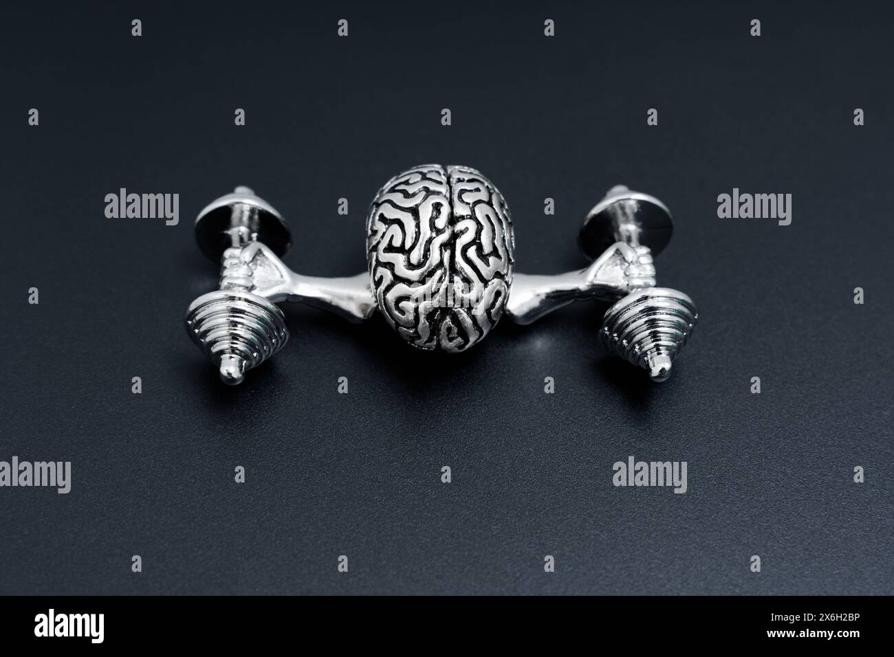 Statuetta del cervello umano in acciaio che solleva manubri pesanti con braccia forti. Concetto correlato all'esercizio mentale. Foto Stock