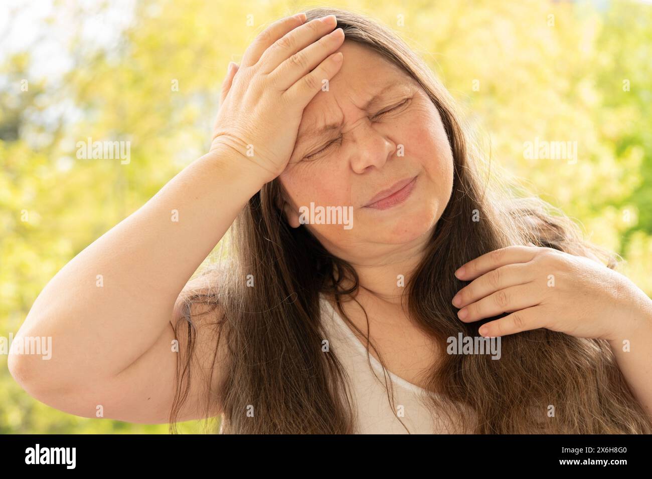 La donna matura malata soffre di forte mal di testa, tenendo la testa, vampate di calore durante la menopausa, diminuzione della memoria e della concentrazione, esausto, menopaus Foto Stock