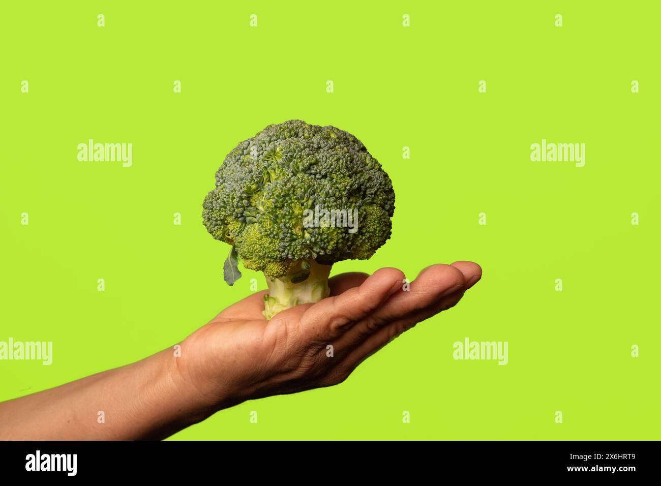 Fresh Start Wellness: Abbracciare scelte sane con Broccoli su sfondo giallo Foto Stock