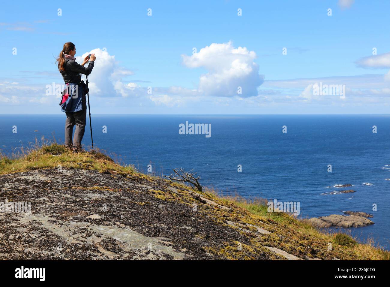 Il turista scatta foto dal sentiero escursionistico lungo la costa del Mare del Nord a Sogndalstrand, nella Norvegia meridionale. Contea di Rogaland. Foto Stock