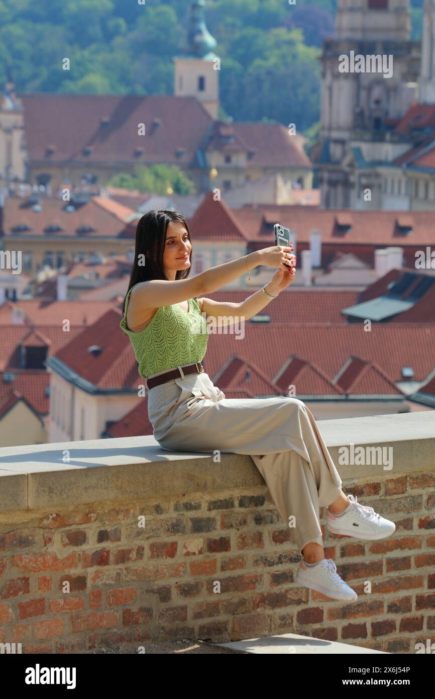 PRAGA, REPUBBLICA CECA - 4 MAGGIO 2024: Donna scatta un selfie con smartphone nel quartiere Hradcany di Praga, Repubblica Ceca. Foto Stock