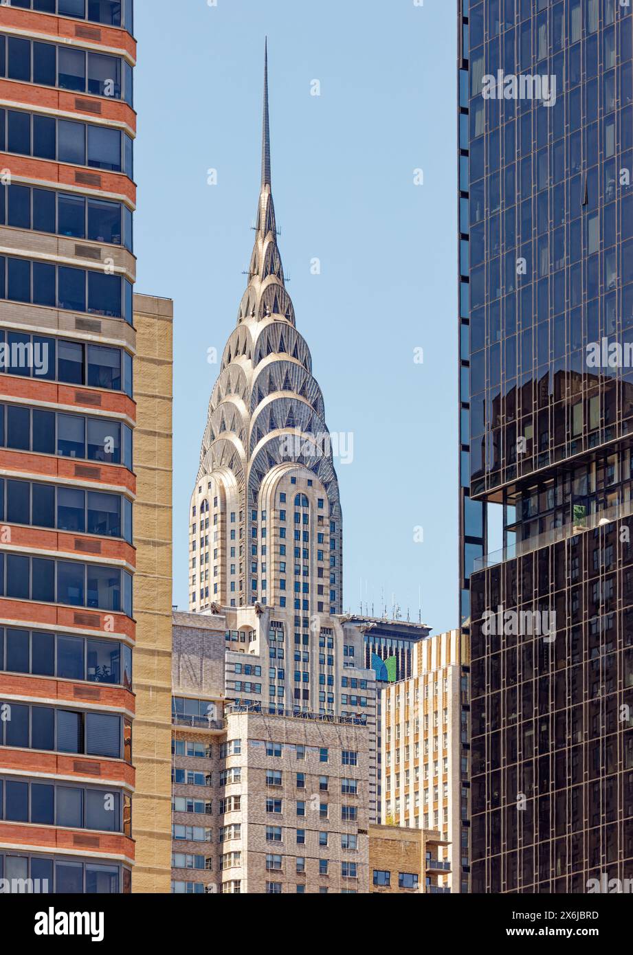 Il Chrysler Building, in stile Art Deco, domina la splendida guglia in acciaio che domina questa vista soleggiata di Midtown Manhattan, presa dal punto panoramico di East River. Foto Stock