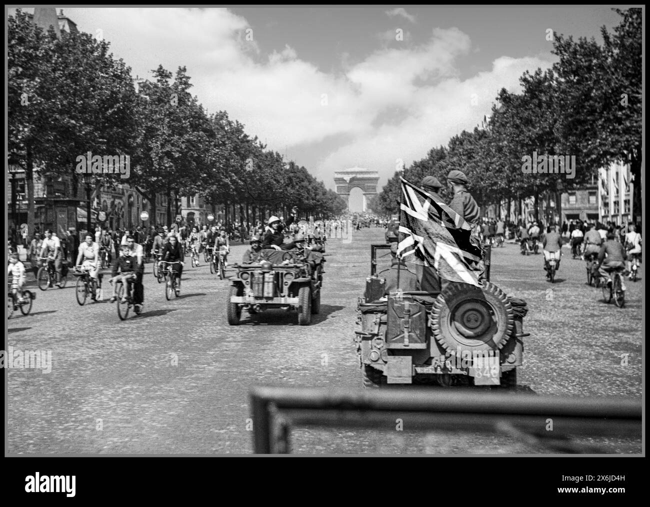 1944 LIBERAZIONE DI PARIGI seconda guerra mondiale un'unità fotografica e cinematografica dell'esercito con la grande bandiera Union Jack guida fino agli Champs Elysees con l'Arco di Trionfo dietro Parigi Francia 26 agosto 1944 Foto Stock