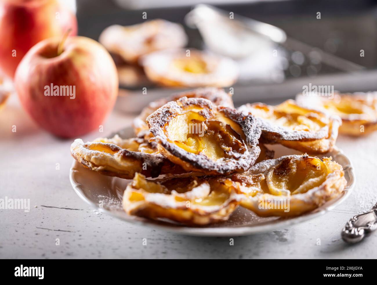 Mini crostate di pasta sfoglia e mele a fette cosparse di zucchero a velo Foto Stock