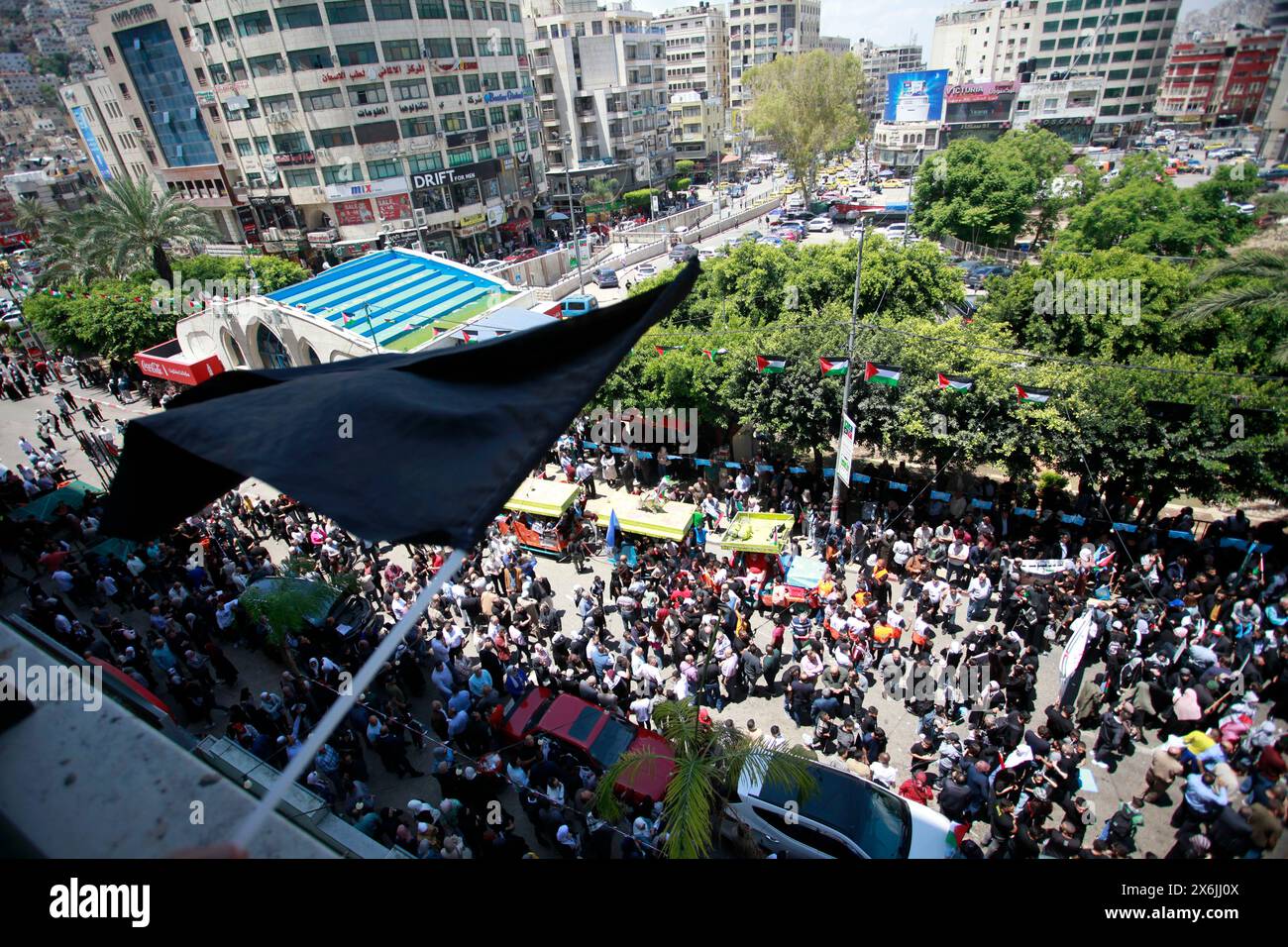 Nablus, Palestina. 15 maggio 2024. I manifestanti tengono bandiere e striscioni palestinesi durante una manifestazione per celebrare il 76° anniversario della "Nakba” o "catastrofe” della creazione di Israele, che ha scatenato l'esodo di centinaia di migliaia di palestinesi nel 1948. I palestinesi segnano 76 anni di espropriazione per commemorare la loro espulsione di massa da quello che oggi è Israele, come una catastrofe potenzialmente ancora più grande si svolge a Gaza, dove più di mezzo milione di persone sono state sfollate negli ultimi giorni combattendo. Credito: SOPA Images Limited/Alamy Live News Foto Stock