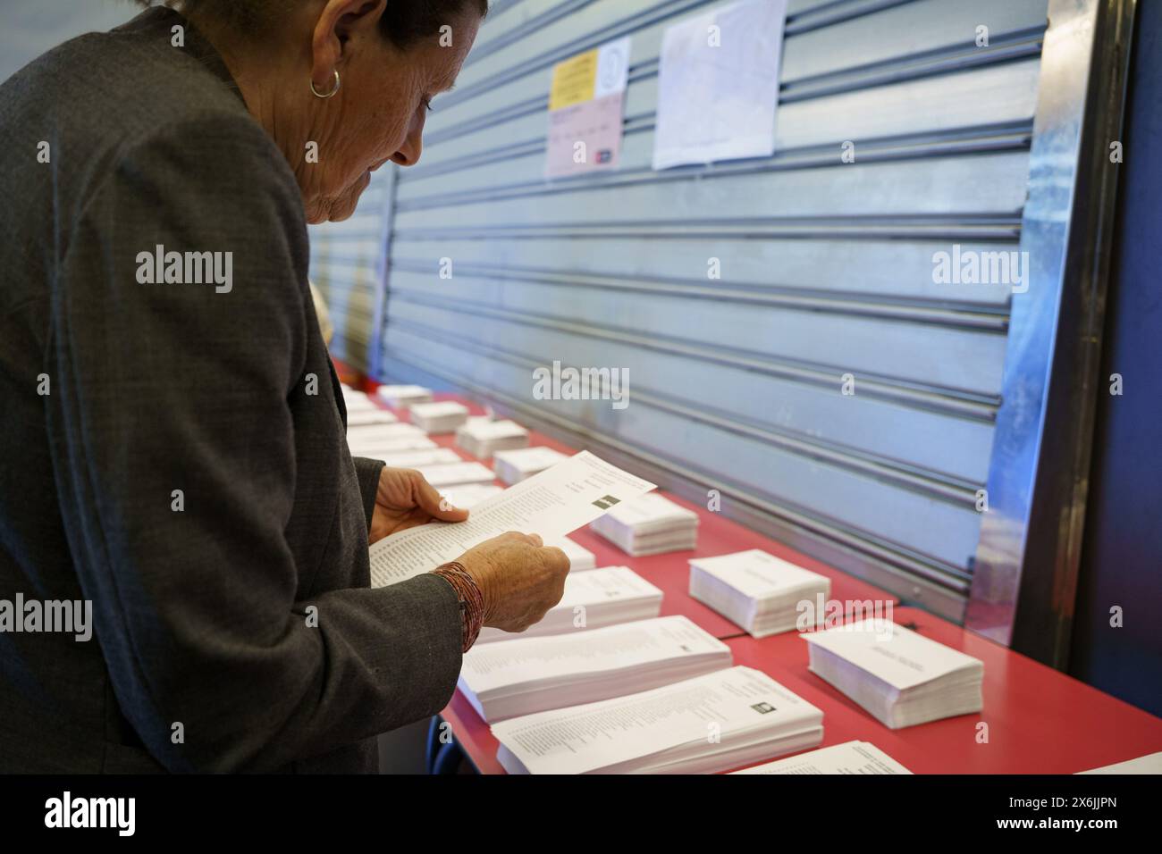 Barcellona, Spagna - 12 maggio 2024: Si vede una donna che prende un voto in un seggio elettorale nel distretto di Guinardo, durante le elezioni nella regione C. Foto Stock