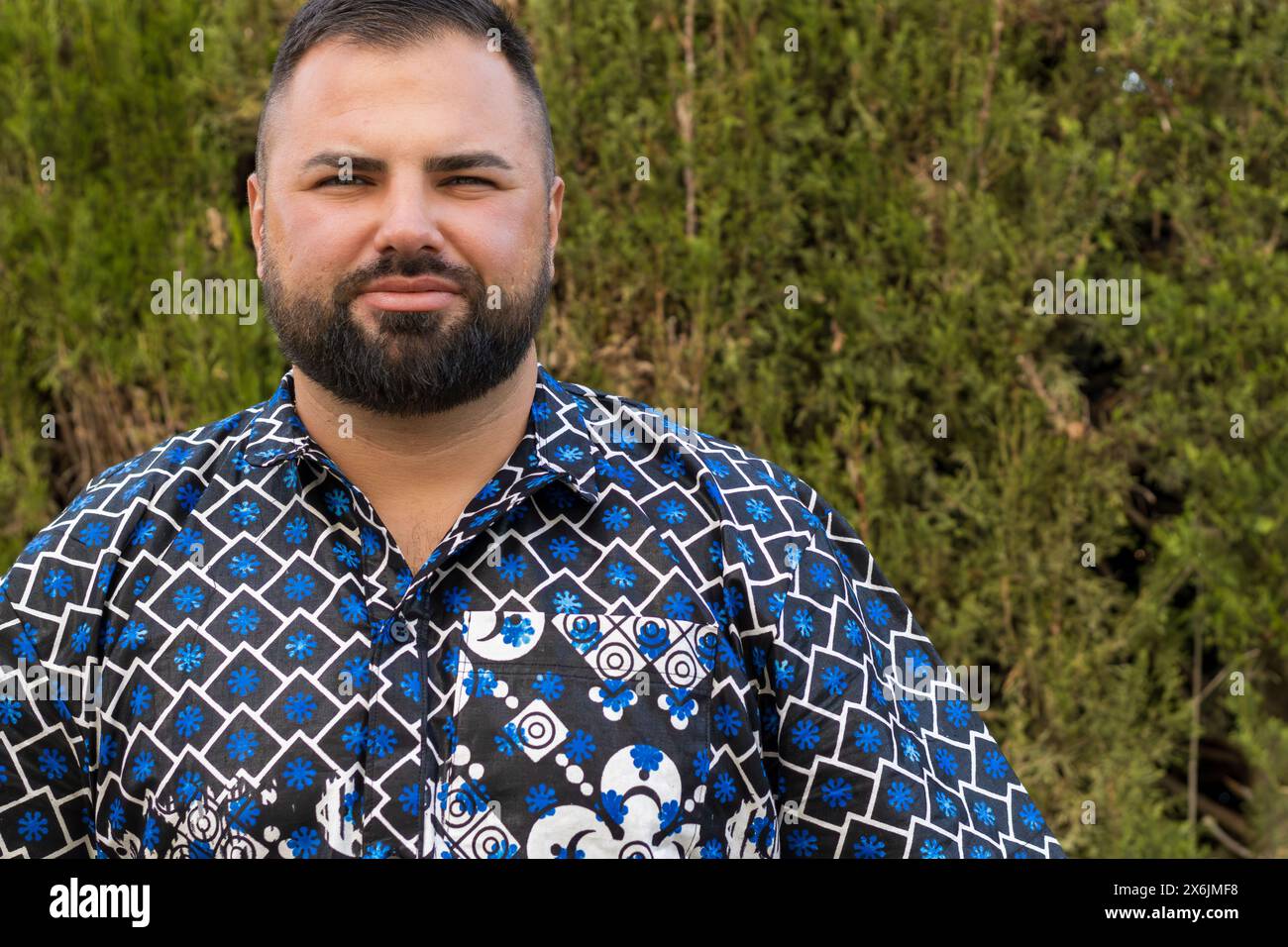 Questo ritratto cattura un uomo di 30 anni la cui espressione facciale trasuda calma e sicurezza. Foto Stock