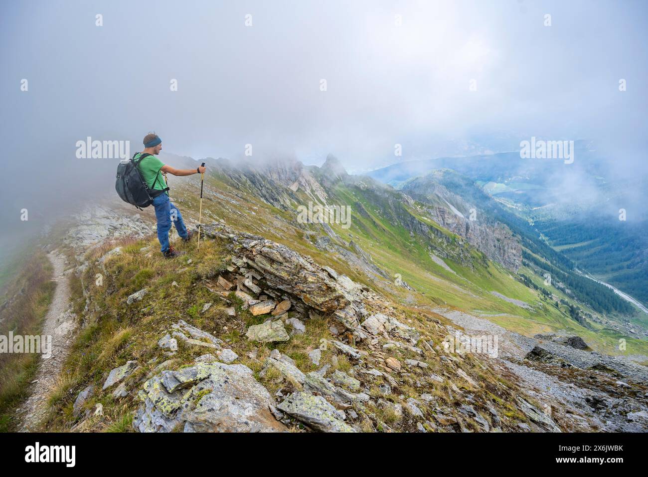 Alpinista su un crinale nuvoloso, crinale principale Carnic, alta via Carnic, Alpi Carniche, Carinzia, Austria Foto Stock