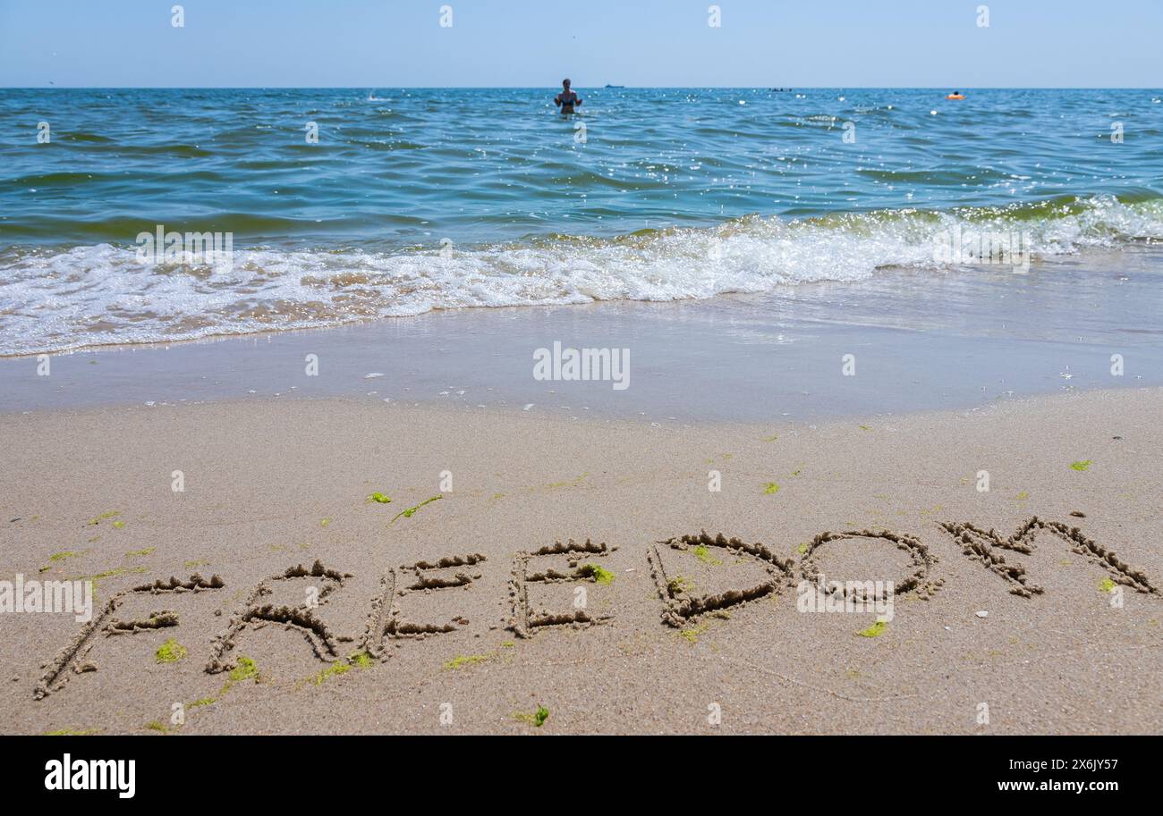 spiaggia, iscrizione sulla libertà di sabbia, spiaggia di mare con onde. Foto Stock